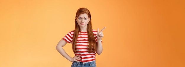 Photo gratuite une rousse douteuse n'achète pas vos pourparlers avec un sourire narquois hésitant à exprimer son incrédulité peu impressionnée par suspi