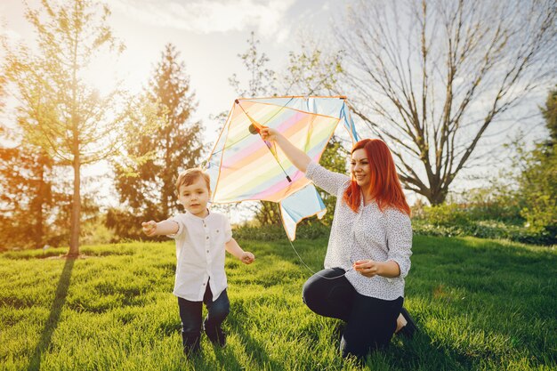 rousse maman dans une blouse blanche jouant avec son petit fils doux je