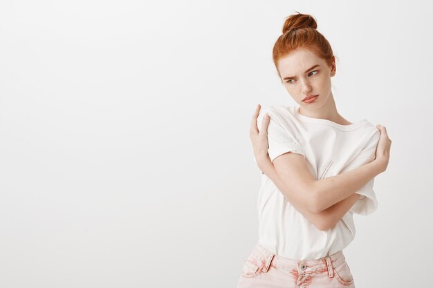 Rousse offensée insécurisée se serrant dans ses bras et paraissant folle à gauche