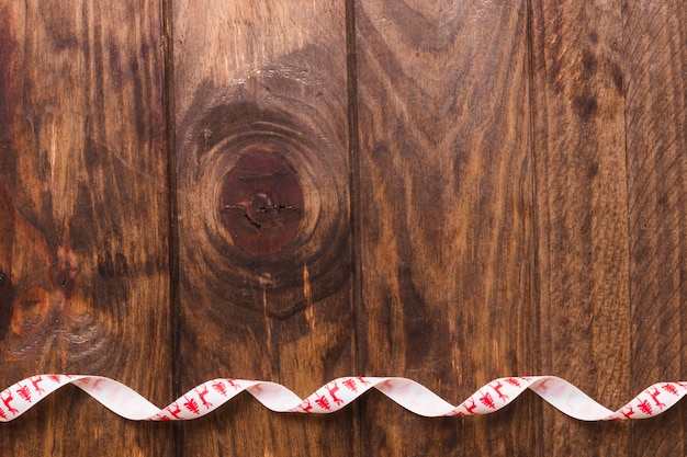 Ruban décoratif blanc bouclé sur une table en bois