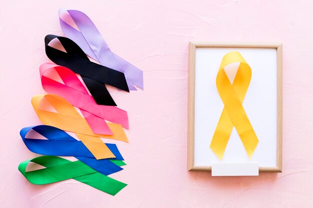Ruban jaune sur un cadre en bois blanc près de la rangée de ruban de conscience coloré