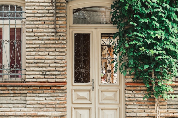 Rues du vieux Tbilissi idée de carte postale ou de publicité La porte et le mur de la maison sont enroulés de lierre