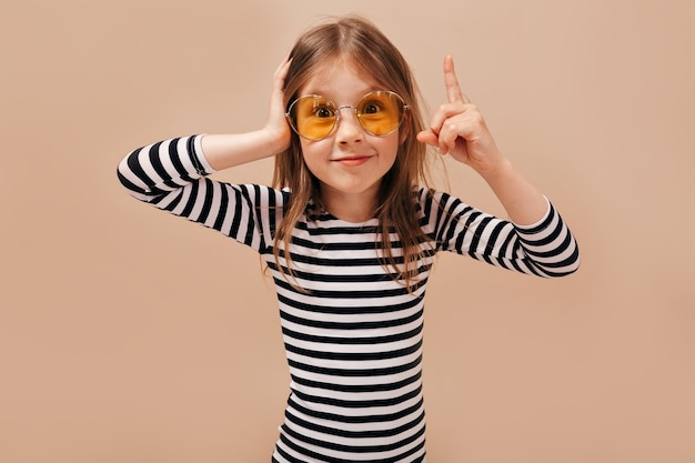 S'amuser, exprimer de vraies émotions positives de joyeuse jeune fille étonnante sur isolé sur fond beige.