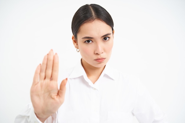 Photo gratuite s'il vous plaît, arrêtez suffisamment de femmes d'affaires asiatiques sérieuses montrant un geste de la main étendu désapprouver