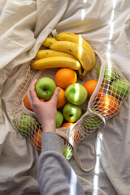 Sac à cordes avec des fruits au lit avec des rayons de soleil