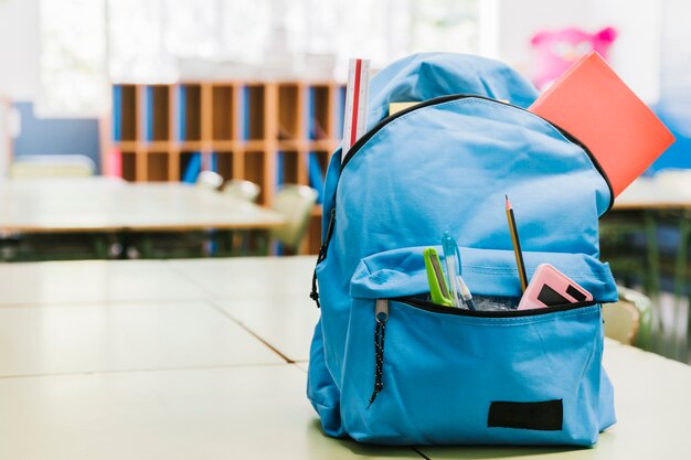 Le sac à dos bleu d'un écolier sur la table