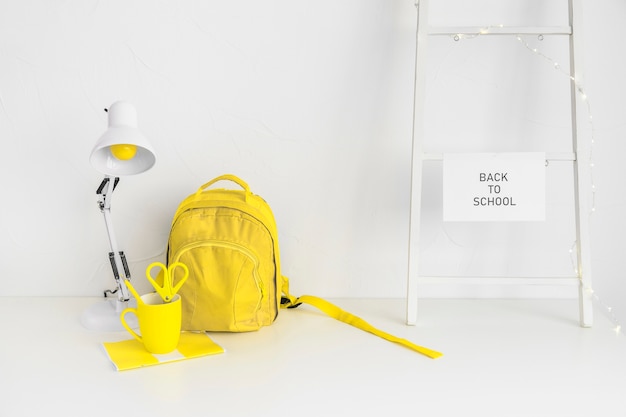 Photo gratuite sac à dos jaune dans l'espace de travail créatif chez les adolescentes