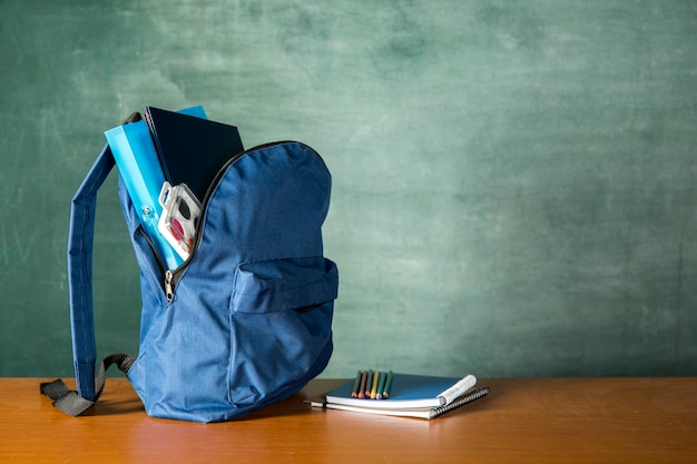 Photo gratuite sac à dos ouvert avec papeterie et aquarelles