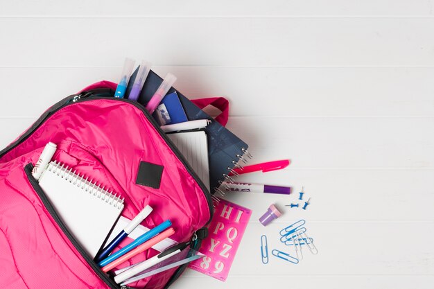 Sac à dos rose avec vue de dessus de fournitures scolaires