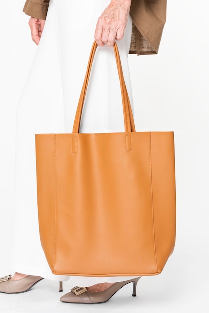 Photo gratuite sac fourre-tout en cuir orange pour femmes vêtements basiques avec espace design