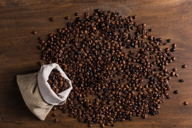 Photo gratuite sac avec des grains de café dispersés