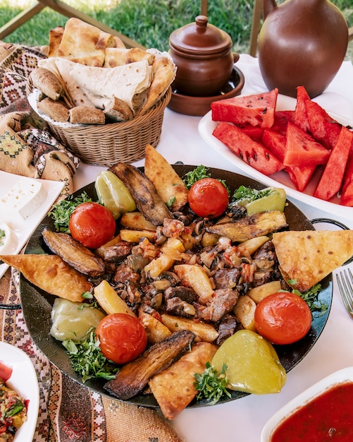 Sac ichi azerbaïdjanais avec divers ingrédients, pain et melon d'eau.