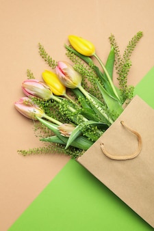 Sac en papier avec des fleurs sur fond bicolore