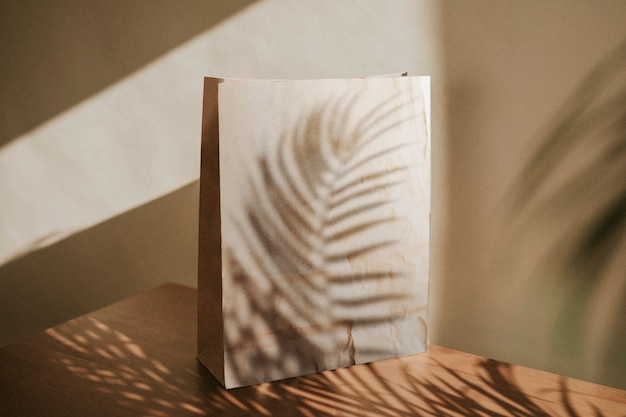 Sac en papier naturel avec ombre de feuilles de palmier