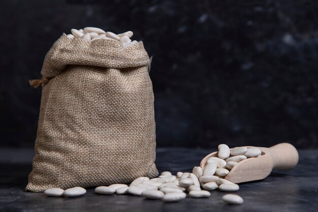 Un sac plein de haricots beurre secs placés sur la pierre