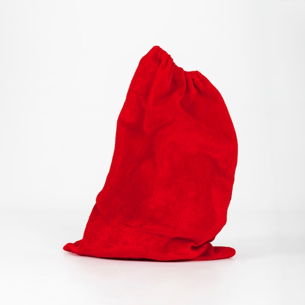 Sac rouge de cadeaux debout sur fond blanc