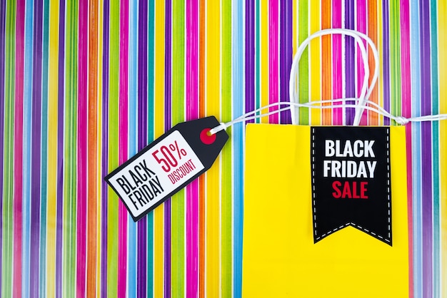 Sac de shopping vendredi noir avec étiquette sur fond coloré