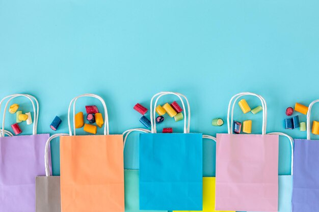 Sacs en papier à plat et gommes à mâcher sur fond bleu