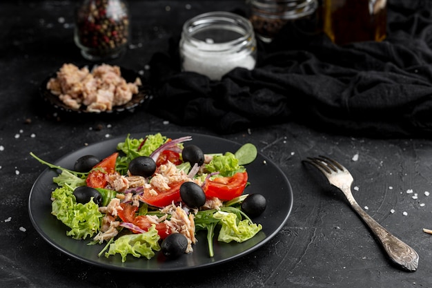 Salade d'angle élevé avec différents ingrédients sur une plaque sombre