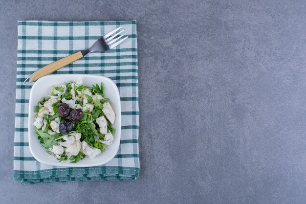 Salade aux olives, herbes et choux-fleurs dans une tasse en céramique