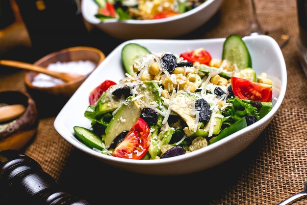 Salade d'avocat concombre corns tomate parmesan noix laitue vue latérale