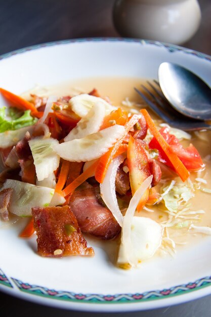 Salade de bacon au style thaïlandais sur assiette blanche