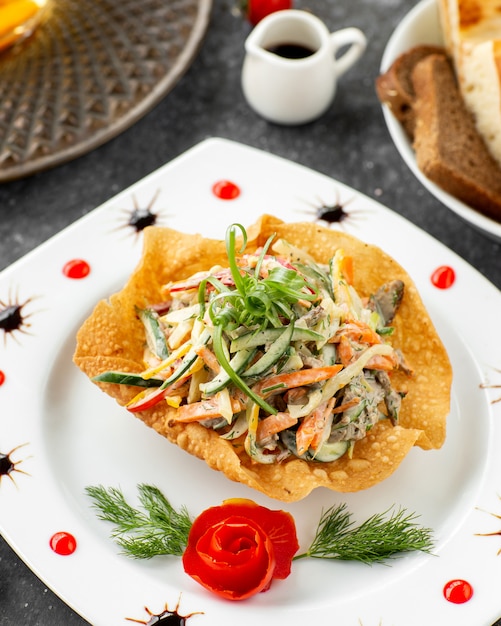 Salade de boeuf aux légumes et mayonnaise servie en croûte de pain plat