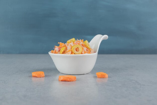 Salade de carottes de couleur orange avec des ingrédients mélangés et des tomates cerises.