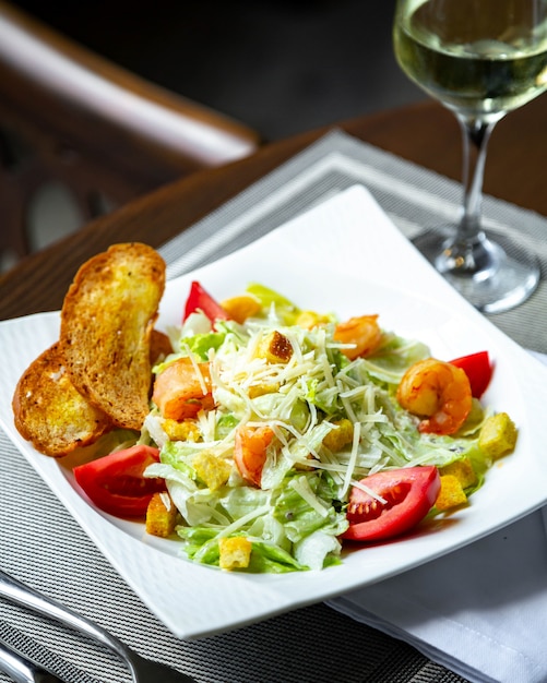 Salade César aux crevettes et verre de vin