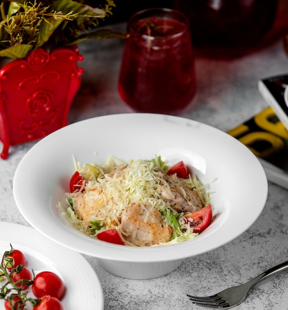 Salade César avec tomate laitue poulet et râpes parmesan