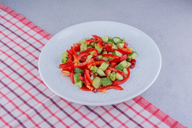 Salade de concombre, poivre et laitue sur une nappe sur fond de marbre. photo de haute qualité