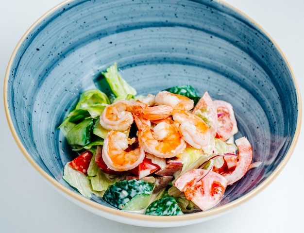 Salade de crevettes aux légumes et mayonnaise dans un bol bleu