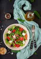 Photo gratuite salade diététique aux tomates, feta, laitue, épinards et pignons de pin. vue de dessus. mise à plat.