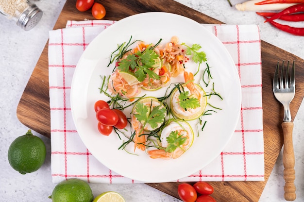 Salade épicée aux crevettes sur une plaque blanche. Nourriture thaï.