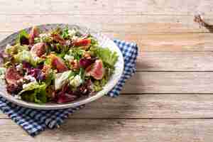 Photo gratuite salade de figues au fromage et aux noix sur table en bois.