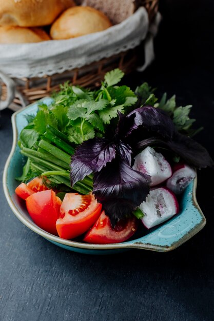 Salade fraîche aux tomates radis et légumes verts servie avec du pain