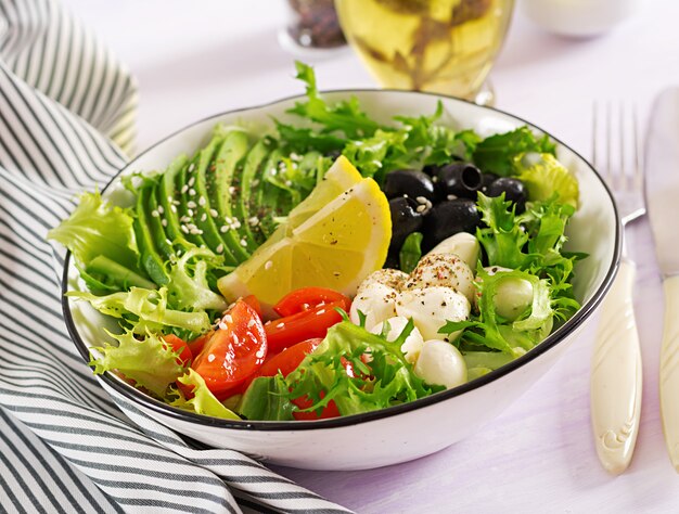 Salade fraîche d'avocat, tomate, olives et mozzarella dans un bol
