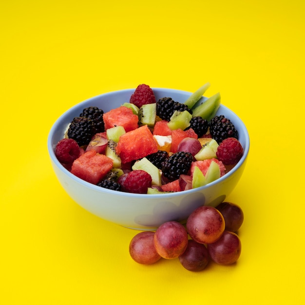 Salade de fruits savoureux sur fond jaune