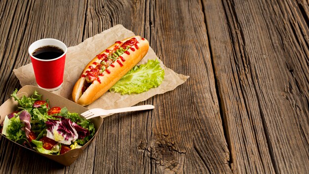Salade et hot-dogs sur fond en bois