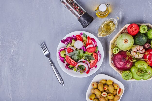 Salade légère aux légumes et herbes servie avec de l'huile d'olive.