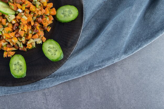 Salade de légumes sur une assiette sur une serviette sur la surface en marbre