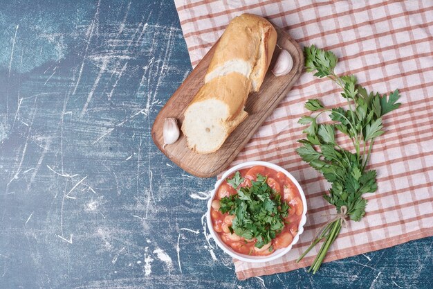 Salade de légumes aux herbes et épices servie avec baguette.