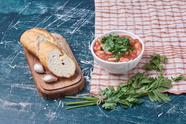 Salade de légumes aux herbes et épices servie avec baguette.