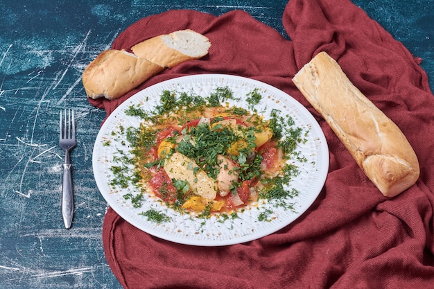 Salade de légumes aux herbes et épices servie avec baguette.