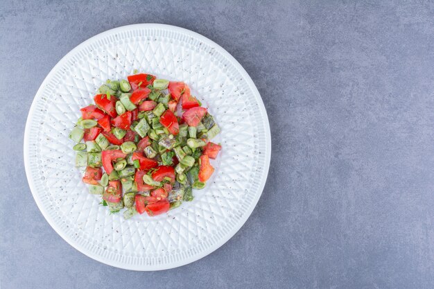 Salade de légumes aux tomates et haricots verts à l'intérieur d'un plat