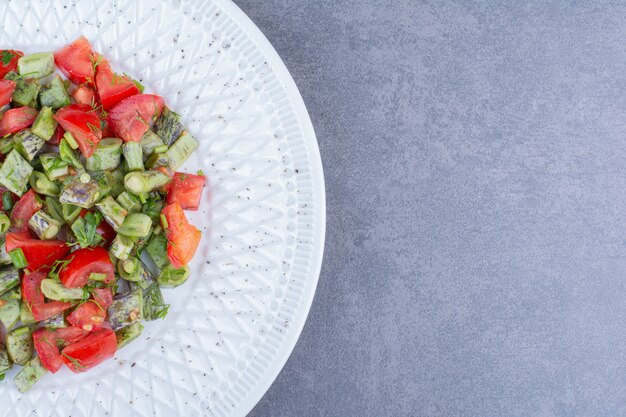 Salade de légumes aux tomates et haricots verts à l'intérieur d'un plat