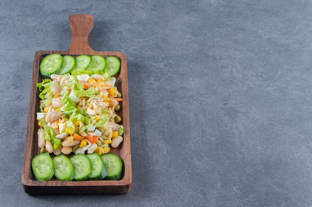 Salade De Légumes Et Concombres Tranchés Sur Une Planche, Sur Le Fond De Marbre.