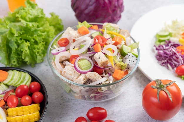 Salade de légumes et de fruits sur une plaque blanche.