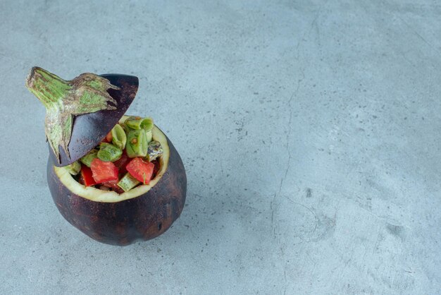 Salade de légumes à l'intérieur d'une aubergine sculptée.