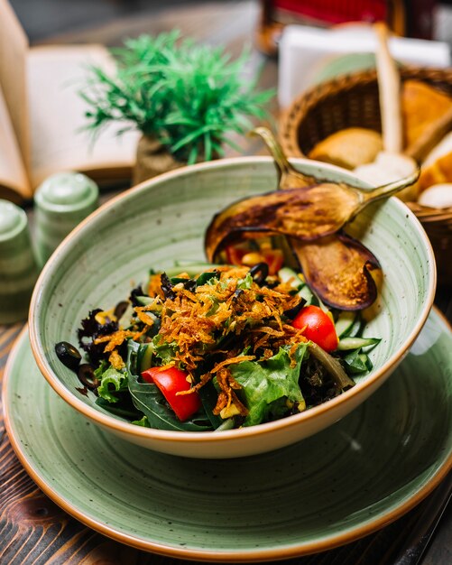 Salade de légumes laitue tomate concombre olives cors aubergines frites vue latérale